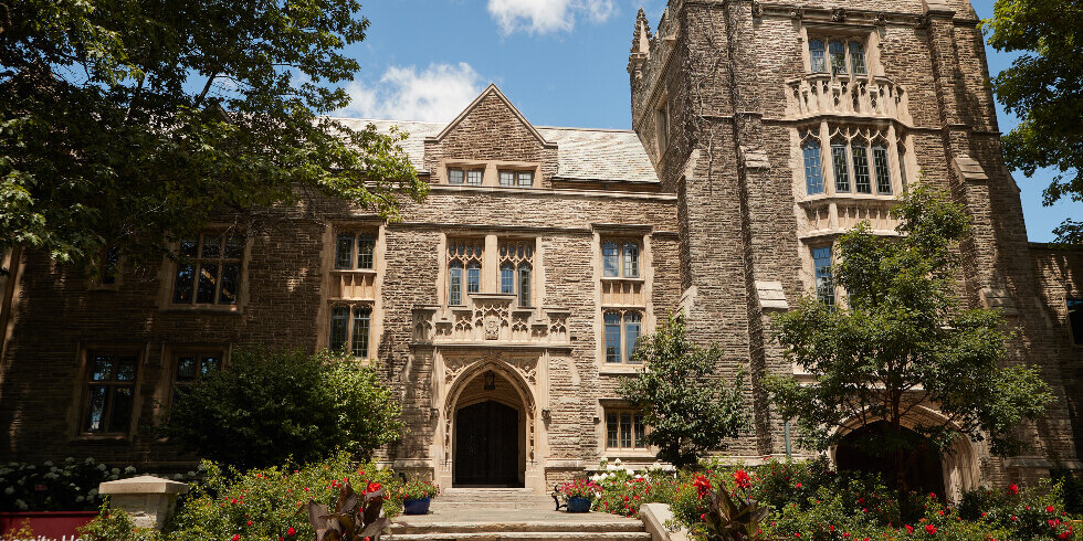 Photo of McMaster University Hall in summer with red roses