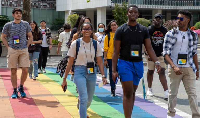 Students walking on rainbow crosswalk.