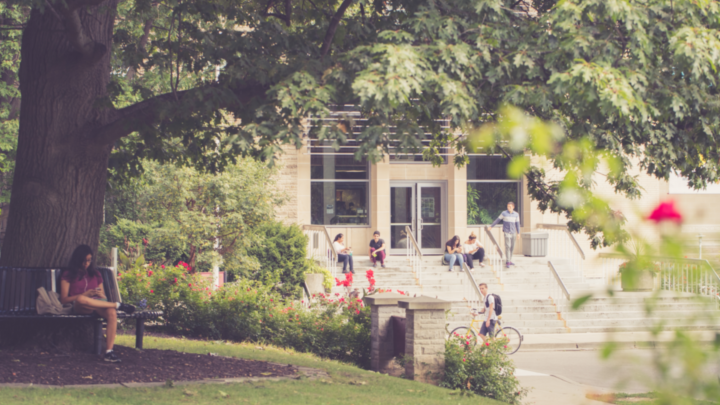 Outside University Hall, students sitting on steps.