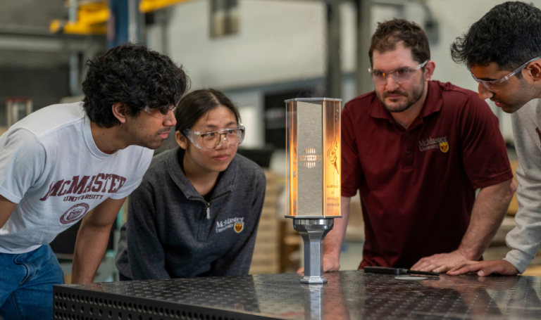 Engineering students and instructor McMaster with a commemorative torch