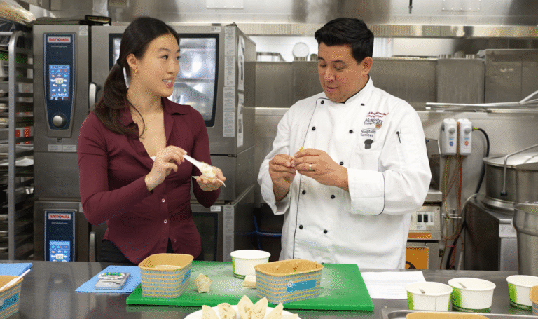 Student teaching chef how to make dumplings.