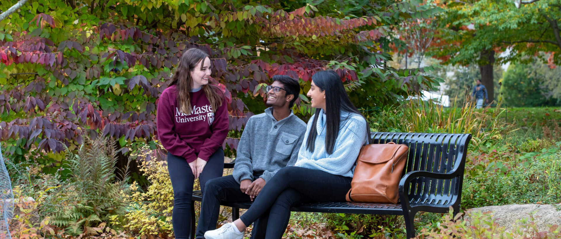 Students sitting on bench outside at McMaster.