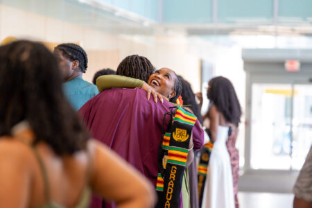 Graduating student hugging family member