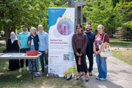 Students and staff around banner for Spiritual Care and Learning Centre